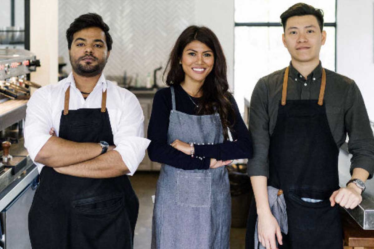 team of three people in aprons left two crossing arms