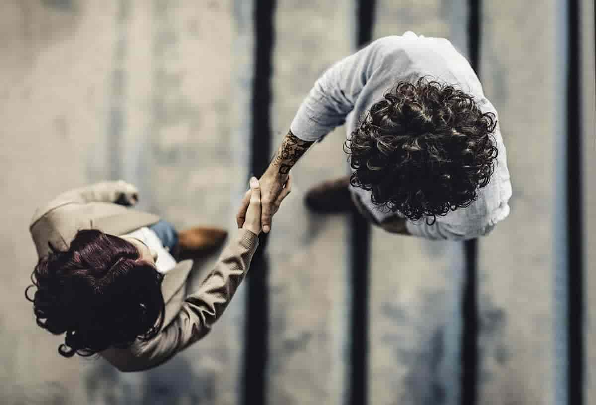 two co-workers shaking hands from above